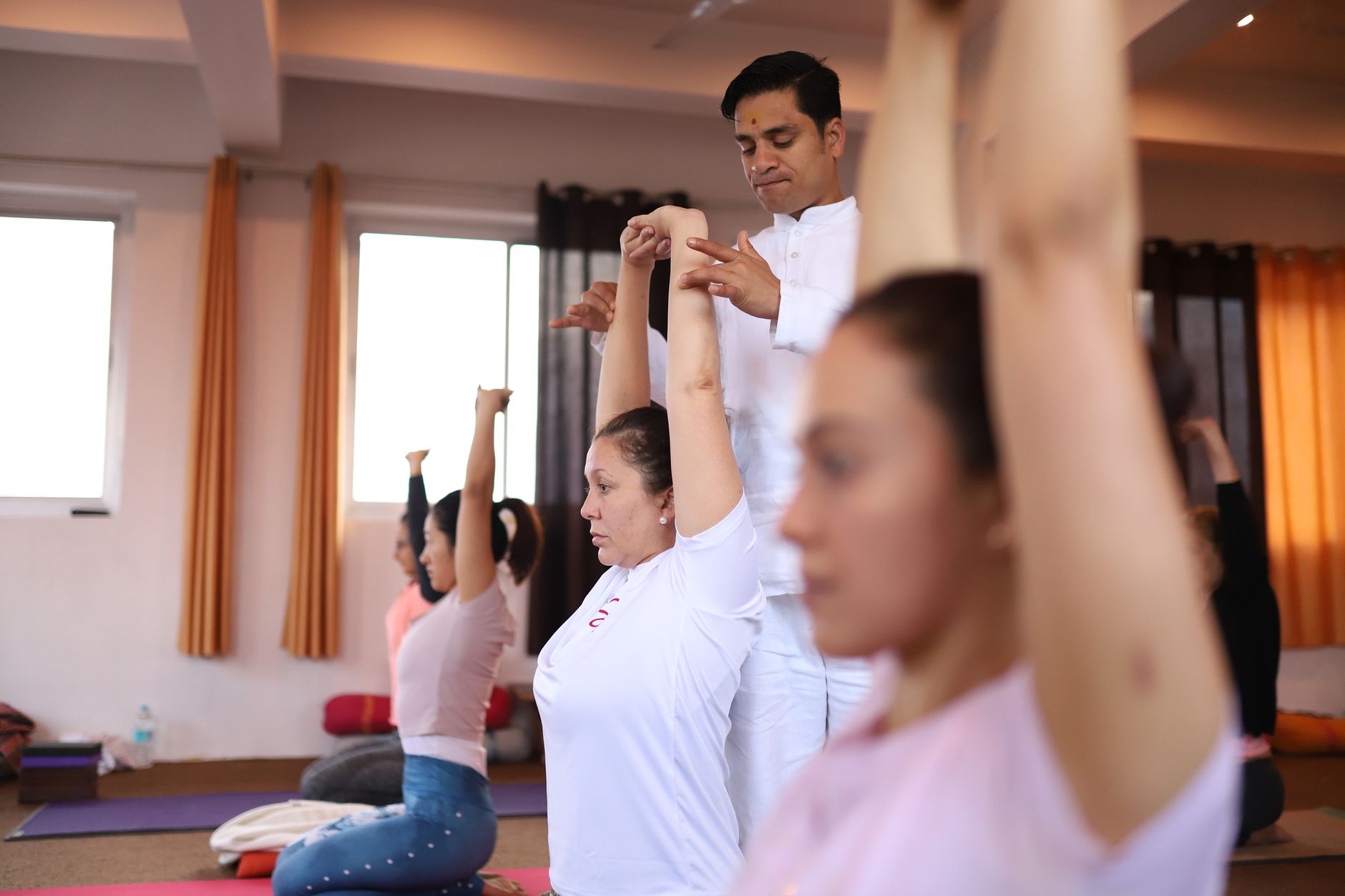 A yoga instructor leading a group session in a bright studio