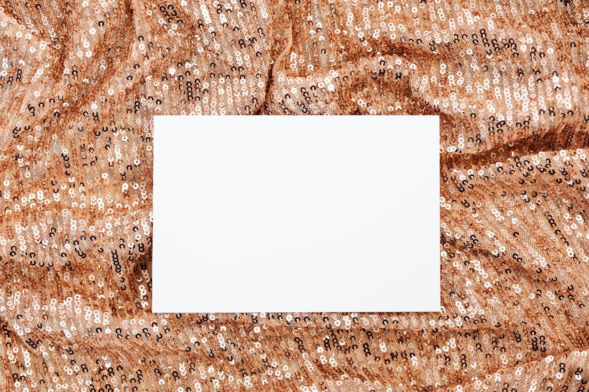 Close-up of sparkling rhinestone and sequin fabric in warm tones