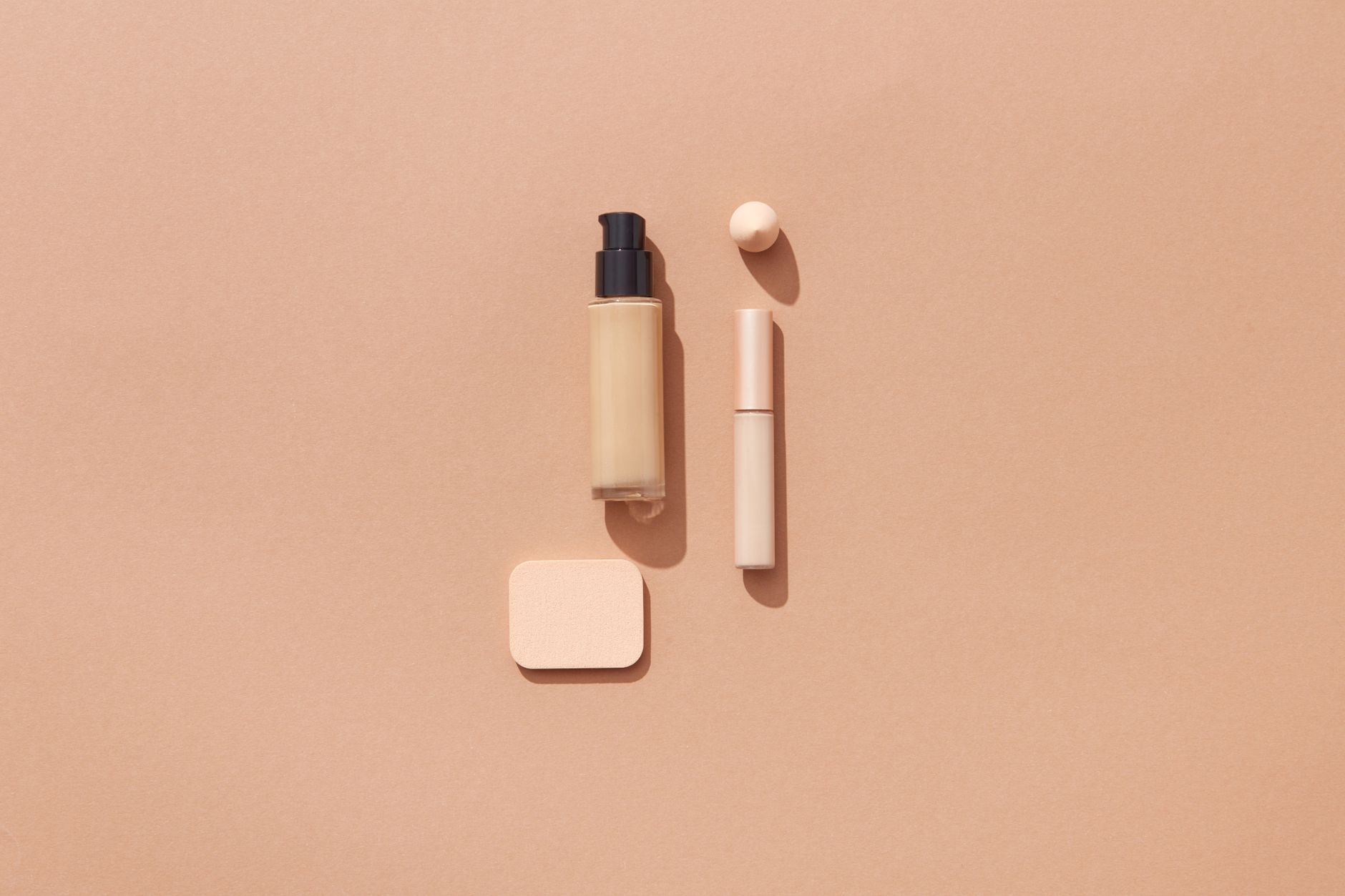 Skincare and fragrance products laid flat on a neutral surface