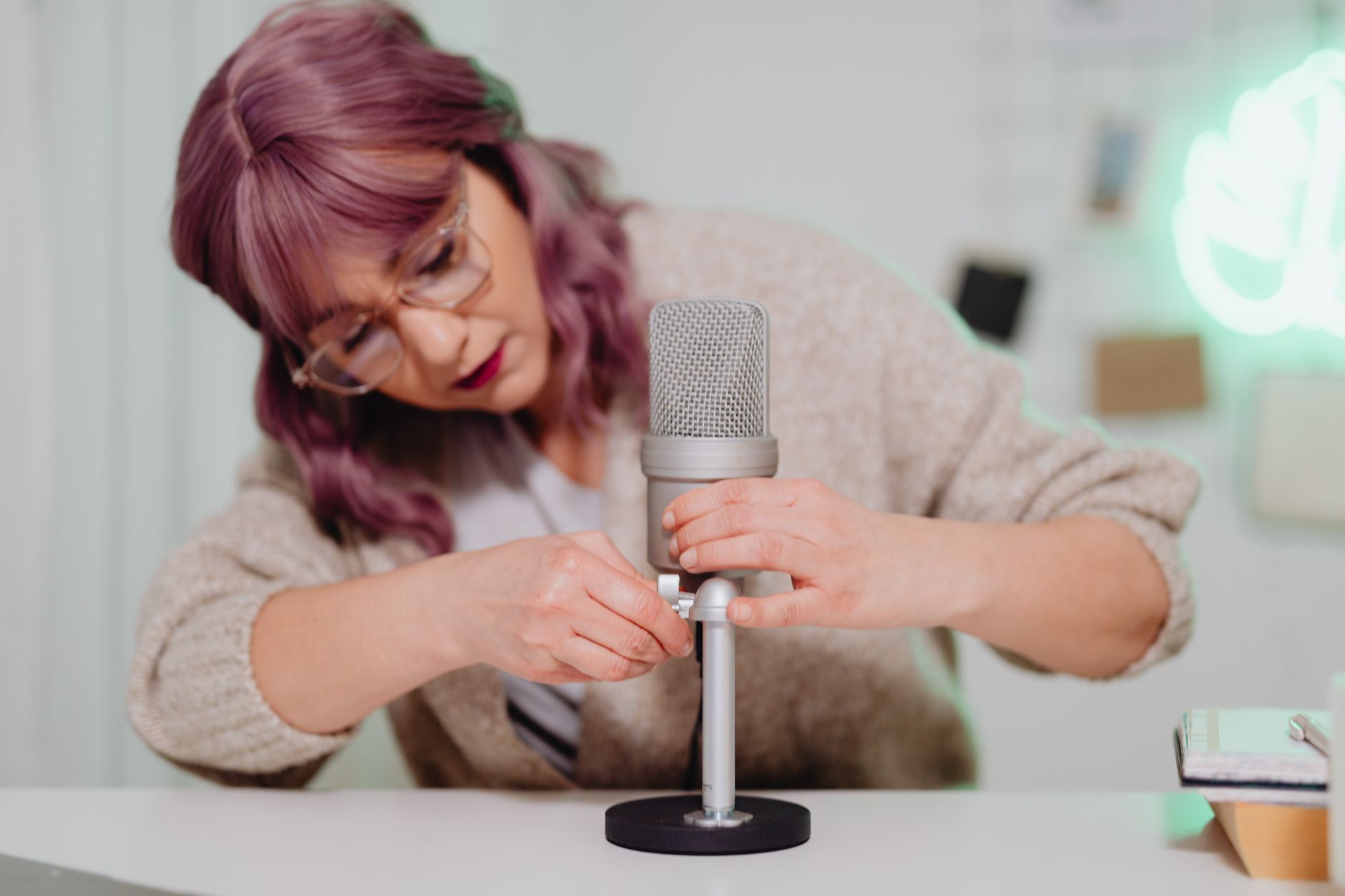 Woman speaking into a podcast microphone at a recording desk