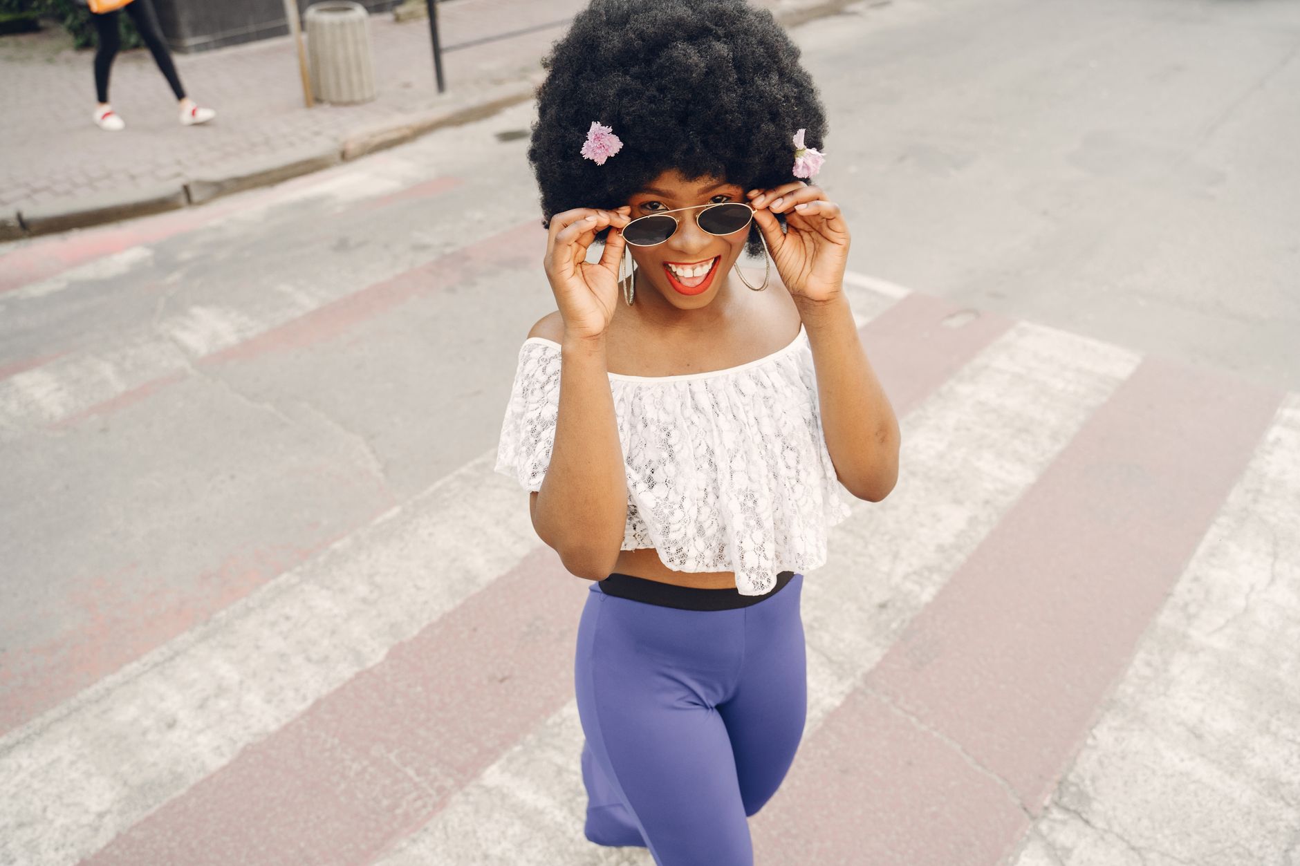A confident Black woman smiling in a bright, natural light setting