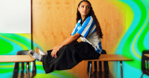 OK, Nike! The Cool Kids’ Guide To Back-To-School Style Student walking on campus in a pleated miniskirt, oversized jacket, and sneakers