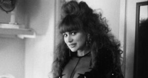 Iris Chacón Built a Stage Where Shame Had No Seat A performer in sequined costume standing in dramatic stage lighting