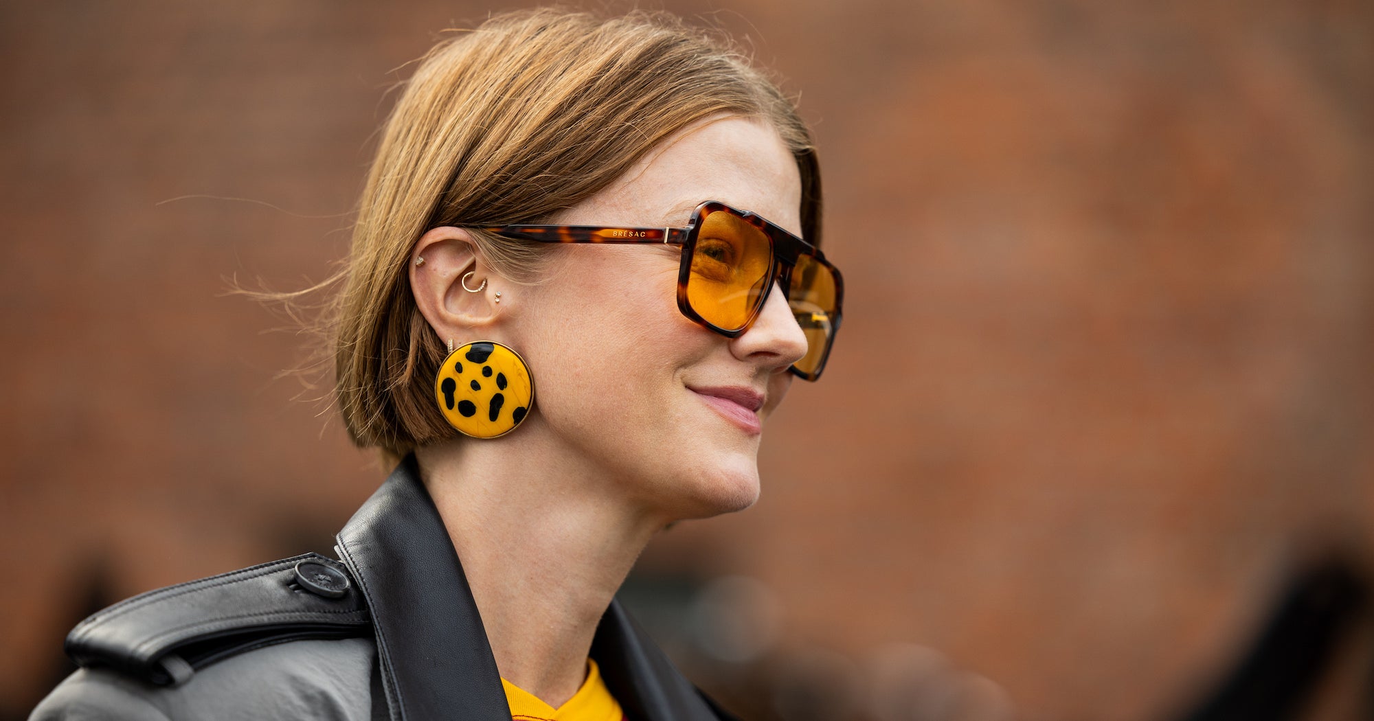 A fashion week attendee with layered hair styled with volume and movement