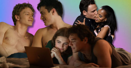 Two people sitting close together on a couch watching television in dim lighting