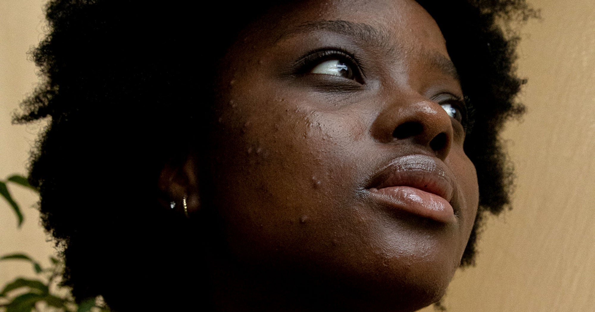 Person applying skincare product to face in natural light