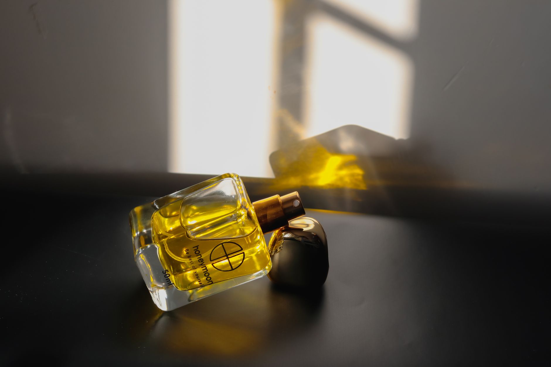Person spraying perfume on wrist in soft natural light