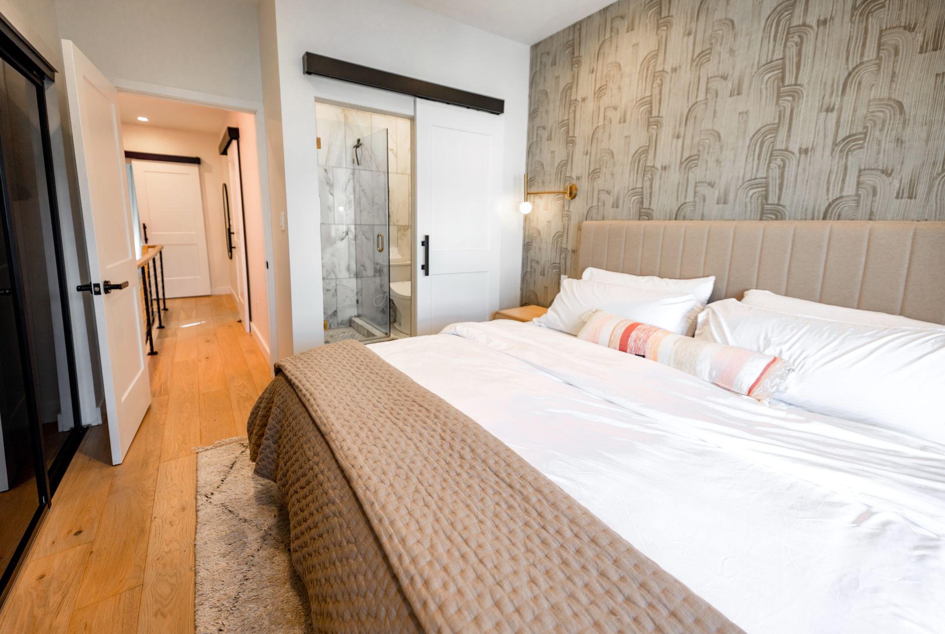 Neatly arranged white linen bedding on a bed in a bright bedroom
