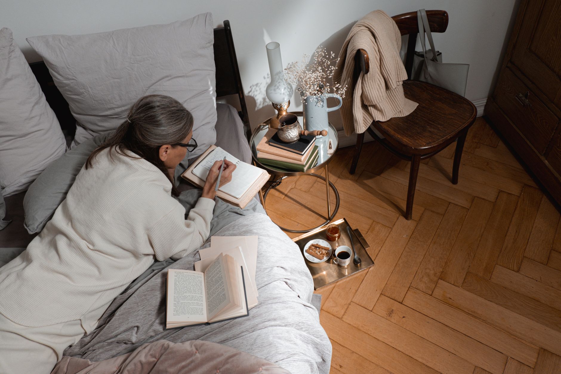 Woman writing in a journal at a quiet morning table with natural light
