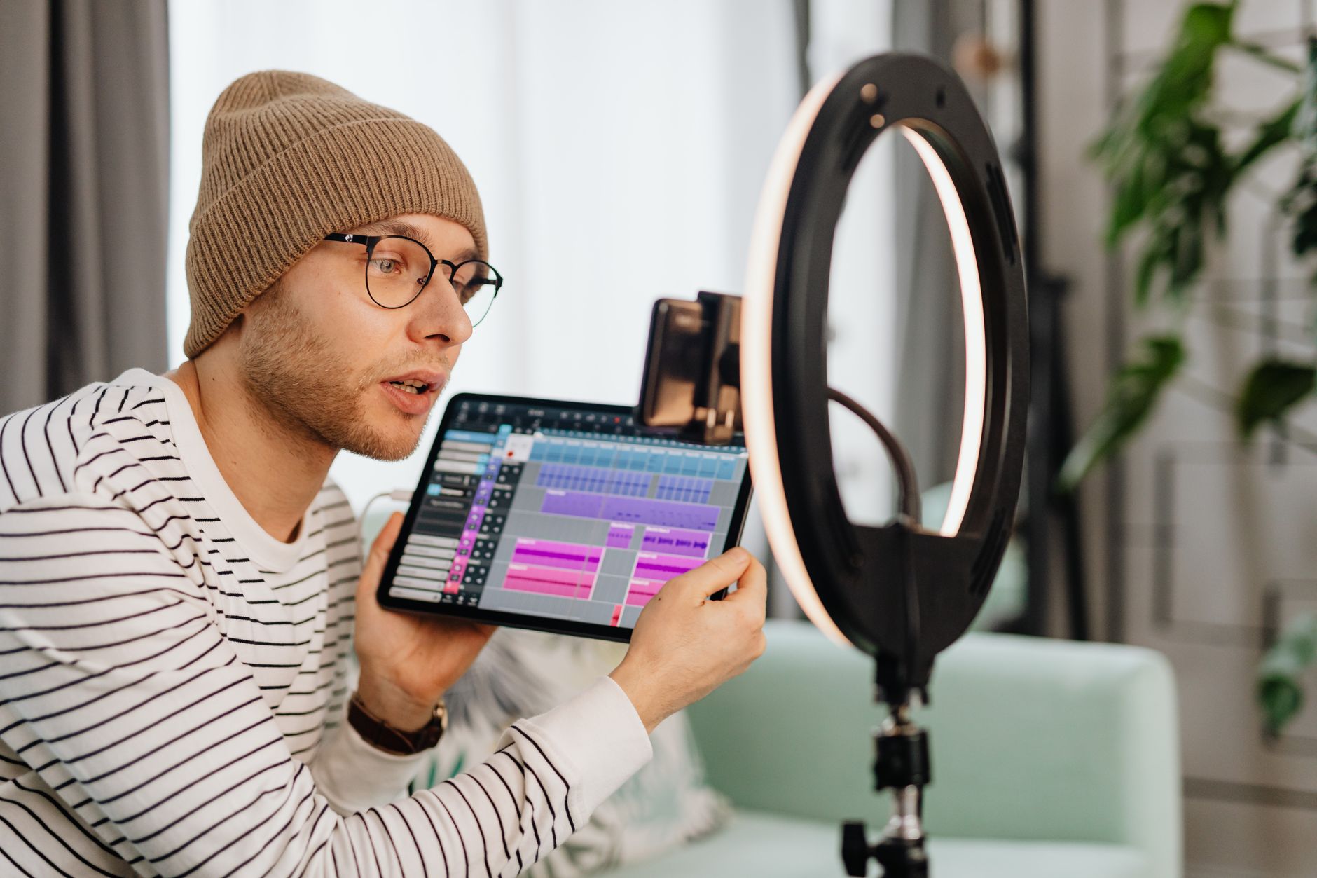 Person setting up a camera for a self-produced video shoot in an informal environment