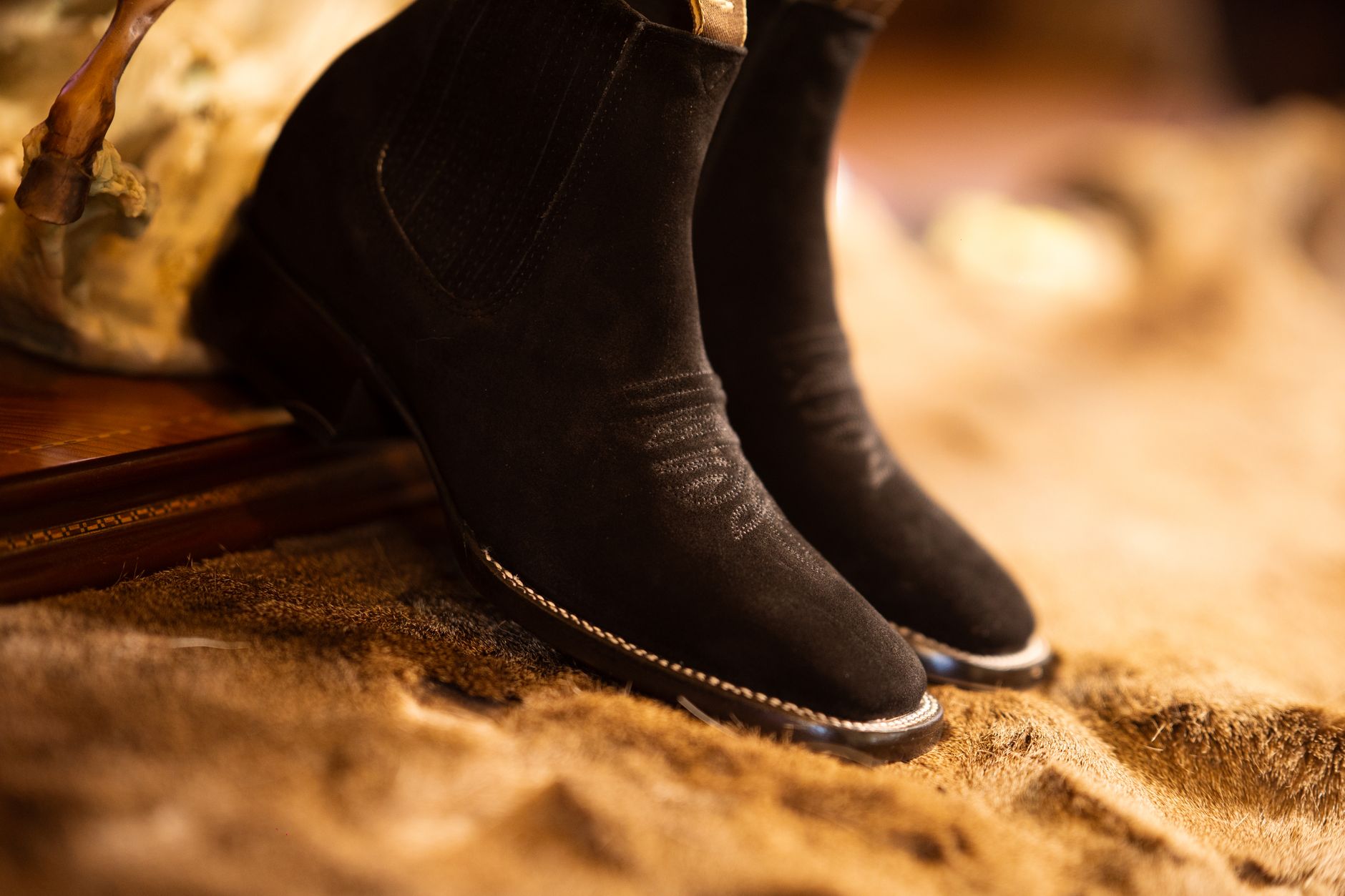 Close-up comparison of suede and leather boots in deep wine tones