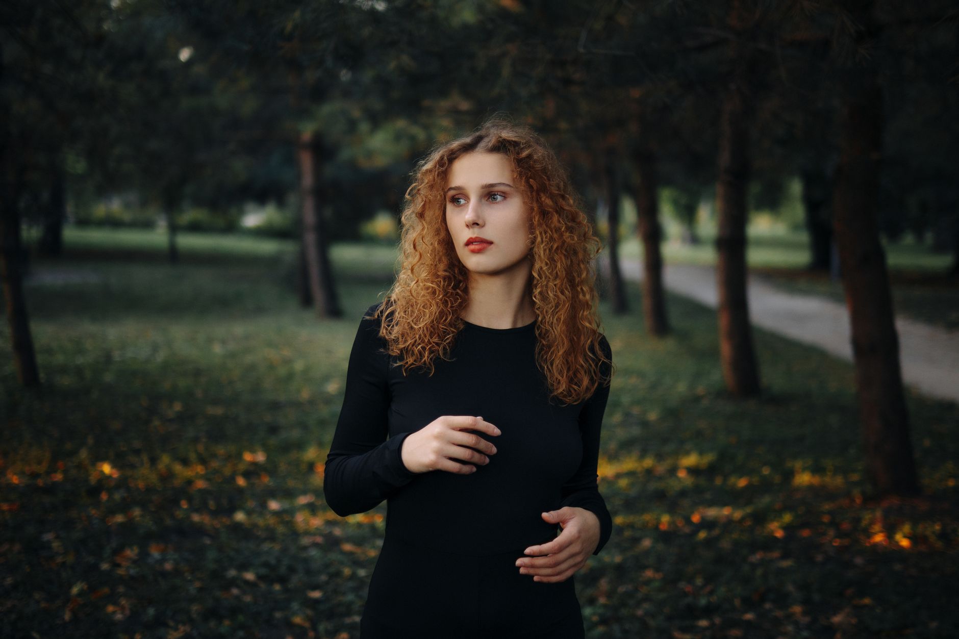 Woman with natural curly hair looking into the distance, representing the Rizos Curls brand ethos