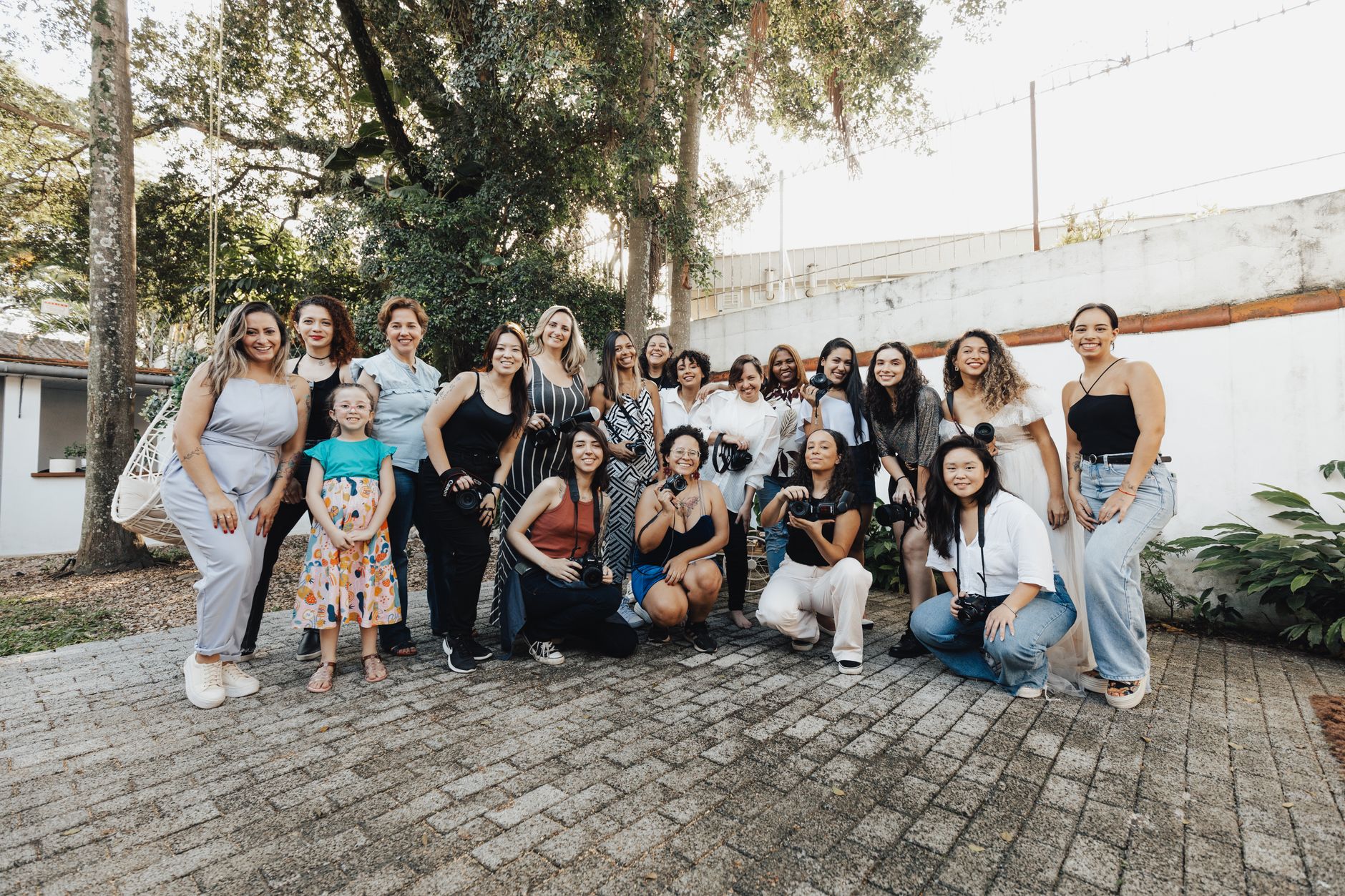A diverse group of women gathered outside in a green natural setting