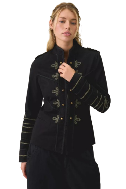 A model wearing a bold structured jacket on a fashion runway in dramatic lighting