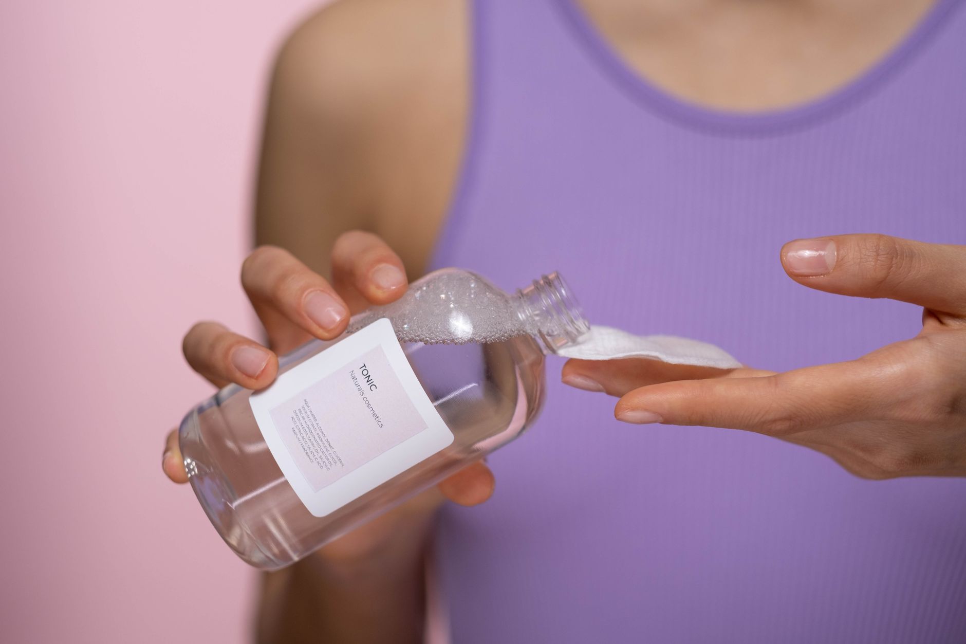 Close-up of skincare toner pads and serum bottles on a bathroom shelf