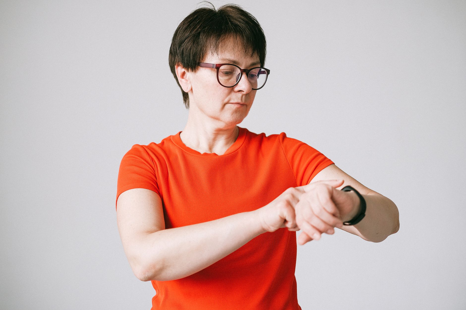 Woman glancing at a fitness smartwatch while walking outdoors