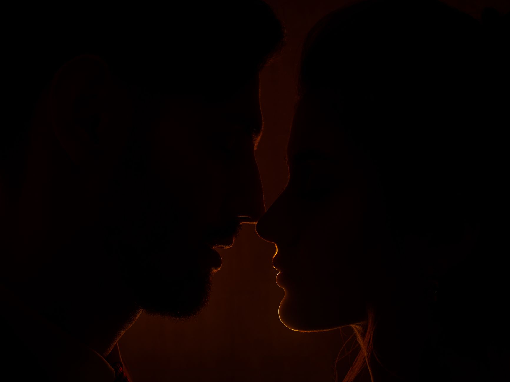 Two people in conversation in low, warm lighting suggesting emotional intensity