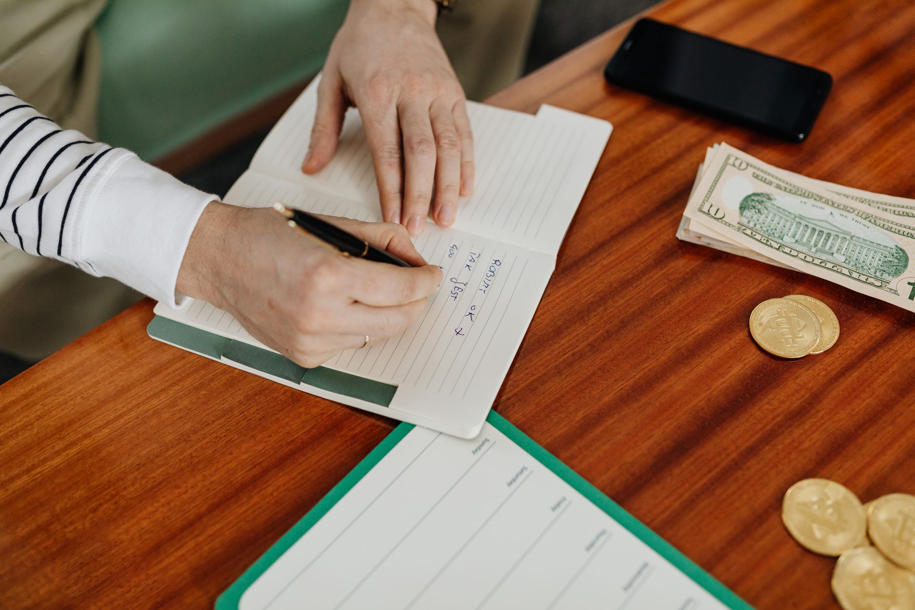 Young woman reviewing finances with a notebook and coffee on a desk