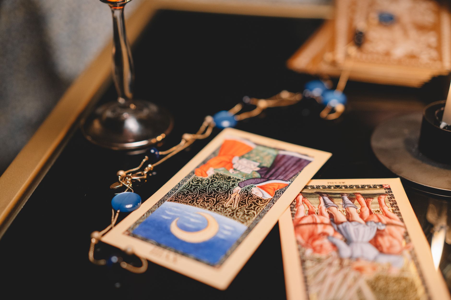 Tarot cards spread across a wooden table with candlelight