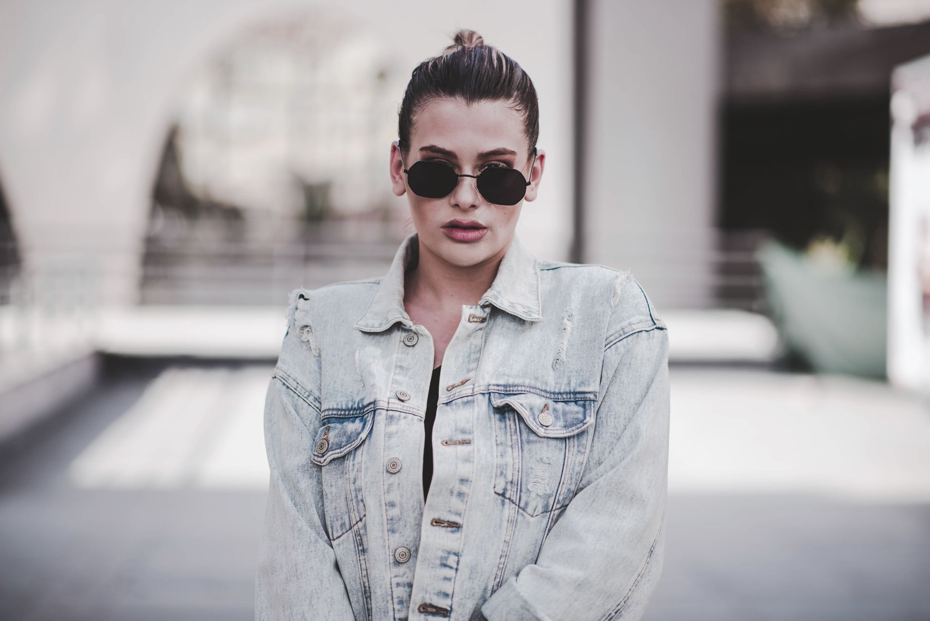 Close-up of denim jeans and elegant flat shoes on a city street in fall