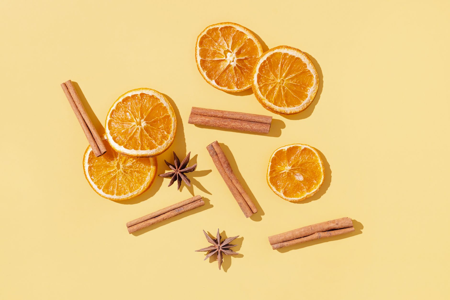 Autumn spices including nutmeg and cinnamon arranged near a lit candle