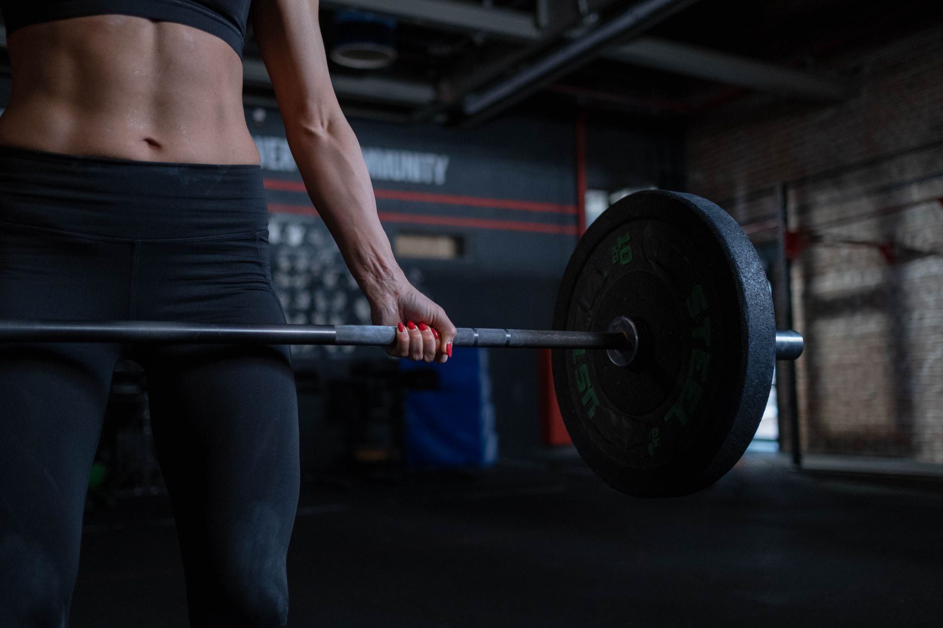 A woman mid-lift in a gym, focused and determined
