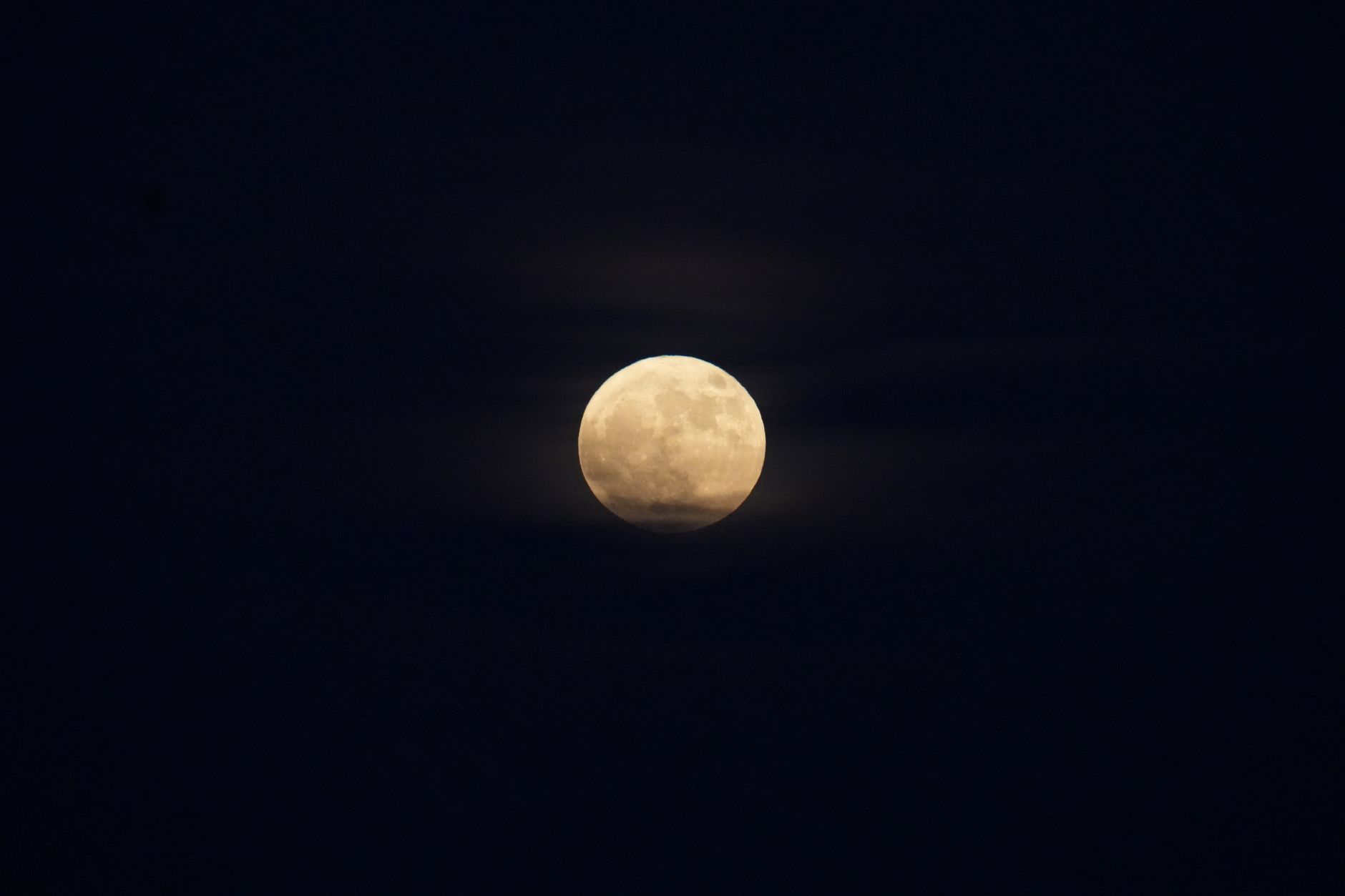 Full view of the moon against a dark blue night sky