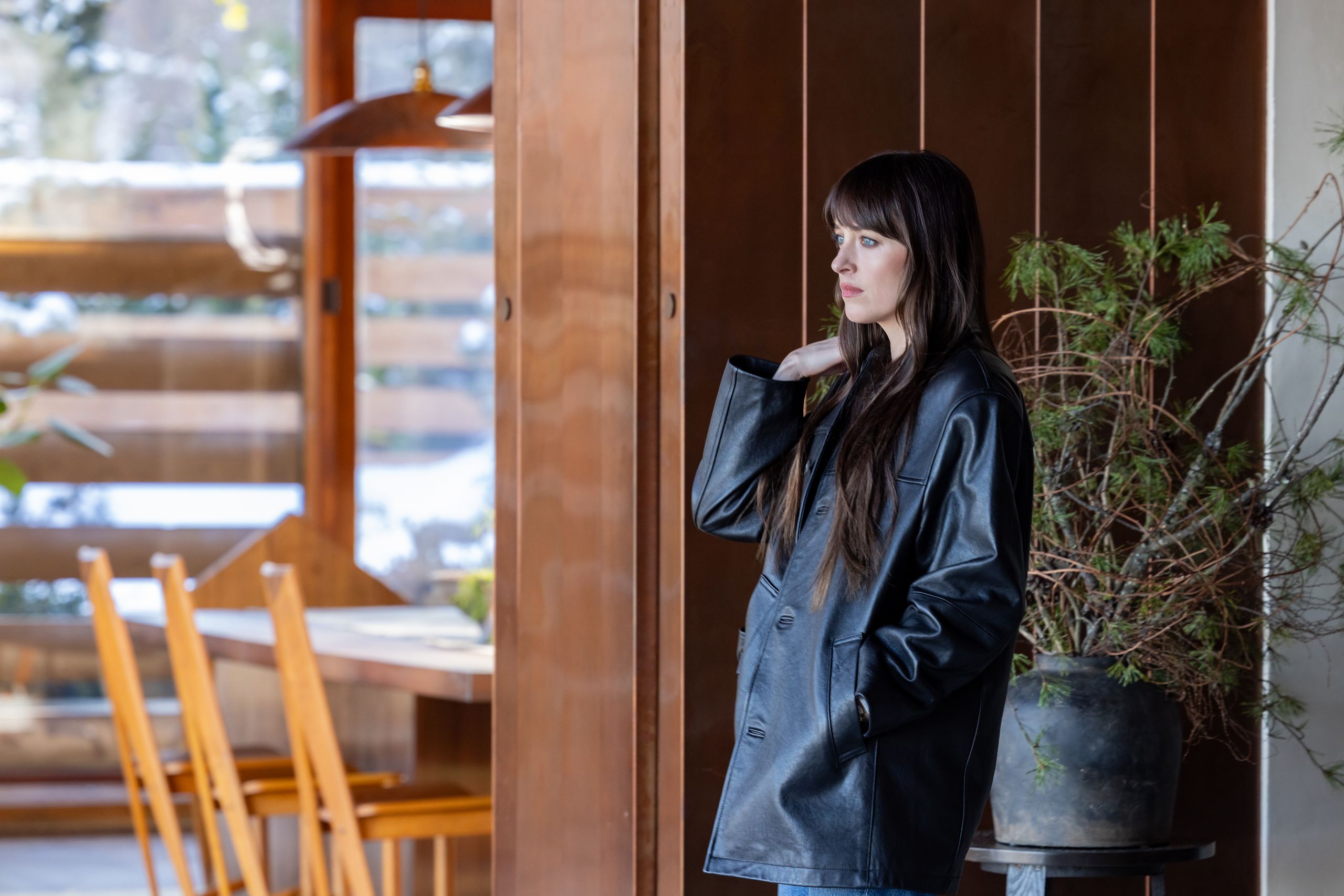 Neatly folded neutral-toned knitwear and linen clothing on a wooden surface